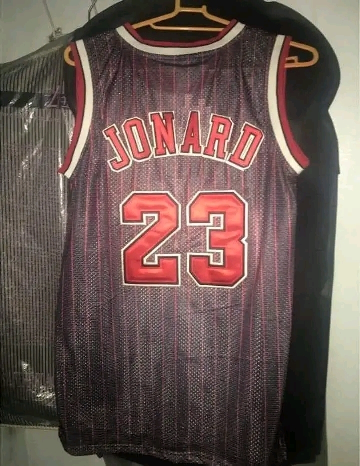 Basketball jersey hanging on a rack, with "Jonard" and the number "23" printed in red text on the back