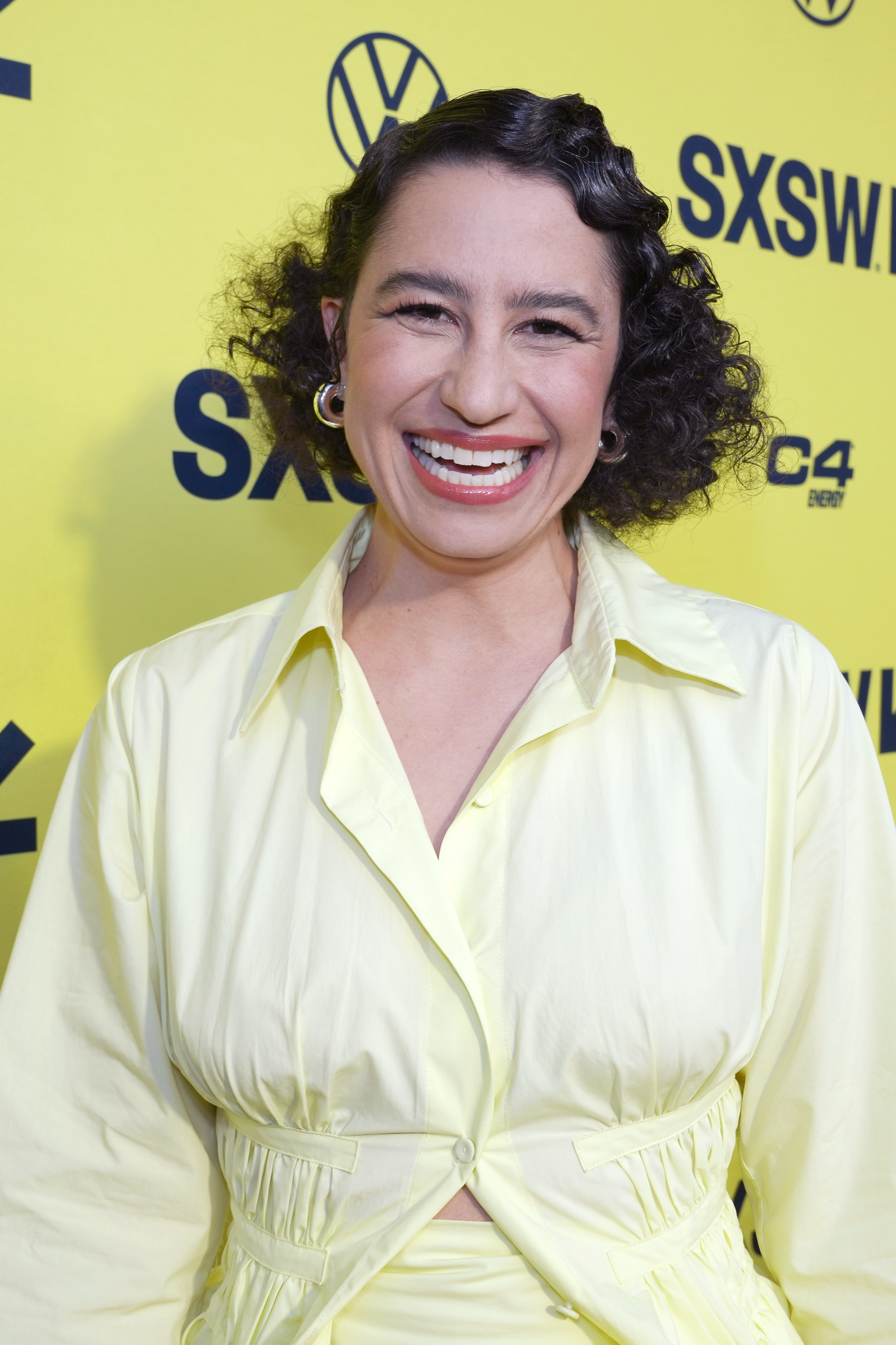 Ilana Glazer smiles broadly while wearing a stylish light outfit at a SXSW event