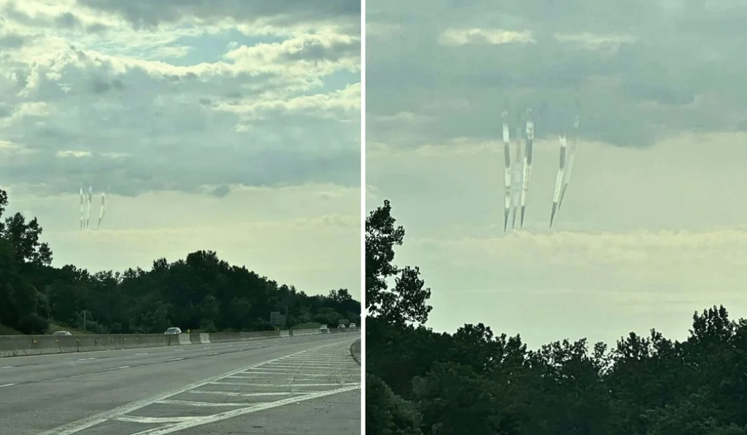 A highway with trees on both sides; the sky has an unusual visual phenomenon featuring vertical streaks