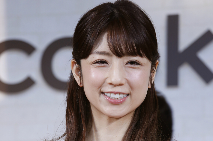 鷲見玲奈さんが微笑んでカジュアルなイベントに登場。彼女は花柄のドレスを着ています。