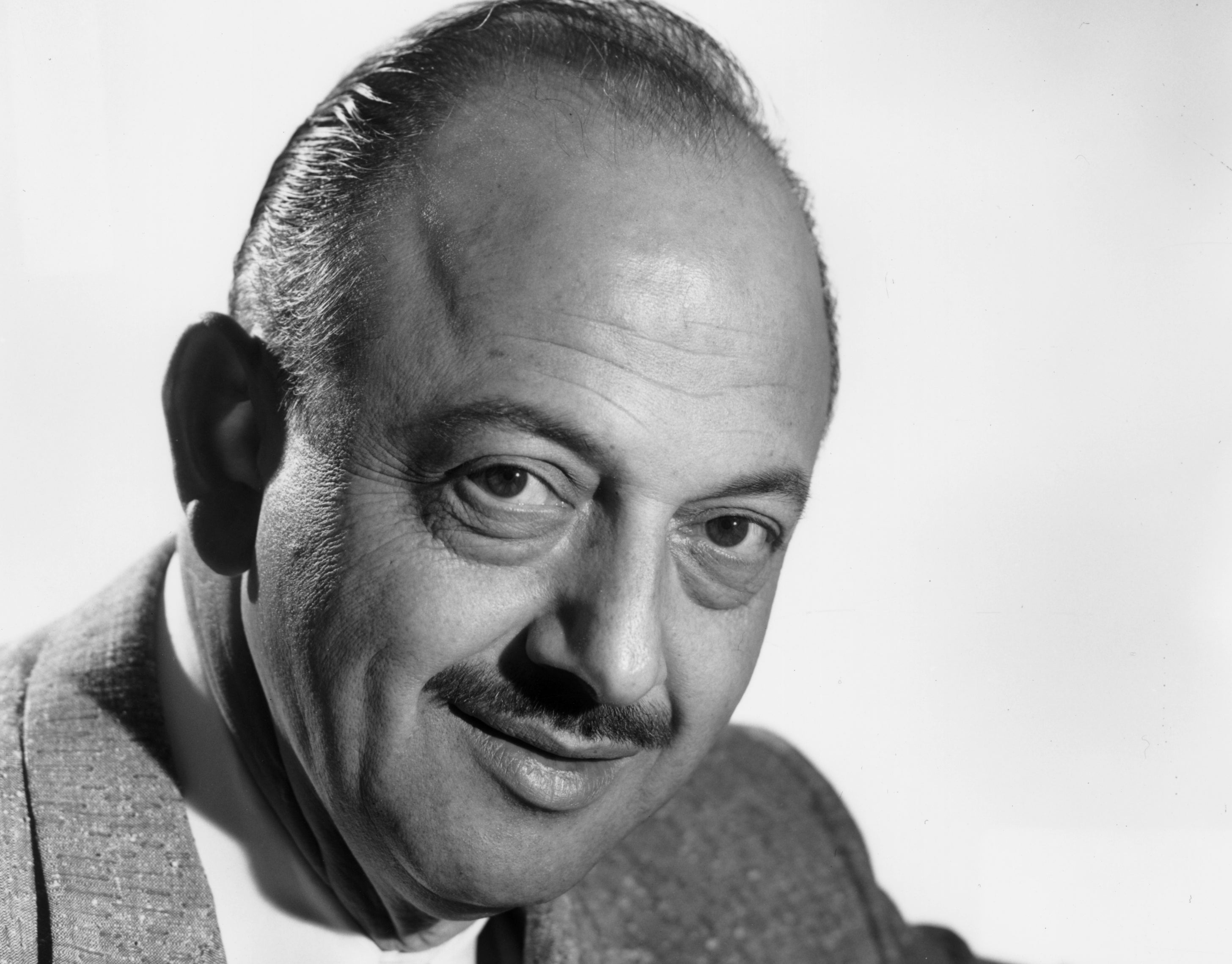 A man in a suit and tie, smiling slightly