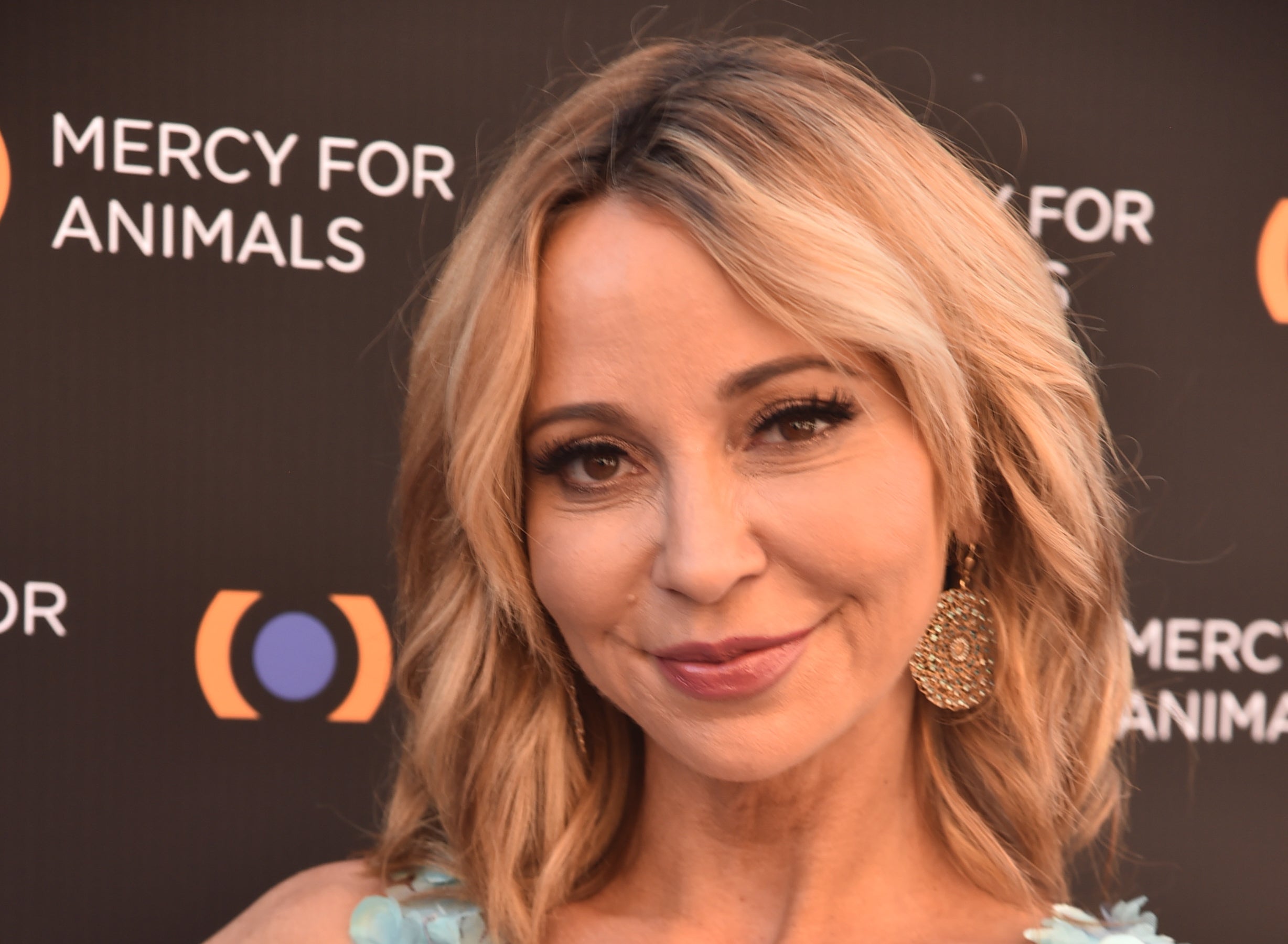 Tara Strong at a Mercy for Animals event, wearing a floral-patterned dress