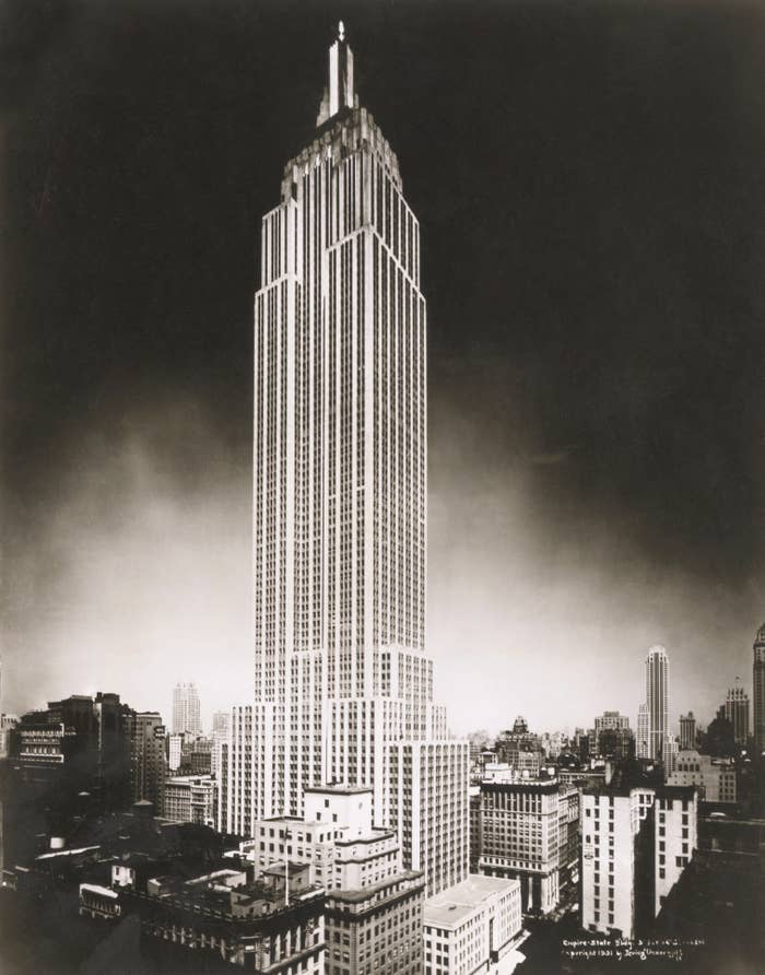 The image shows the Empire State Building towering above the surrounding New York City skyline