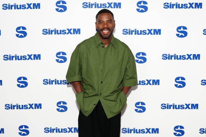 Colman Domingo smiling at a SiriusXM event, wearing a relaxed-fit green shirt and dark pants