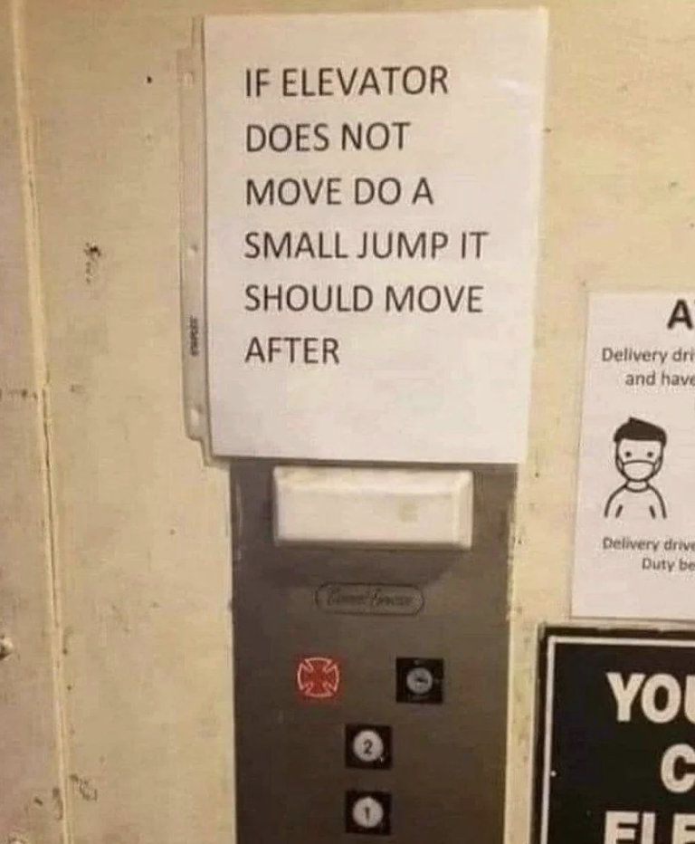 Sign on elevator panel reads: "If elevator does not move do a small jump it should move after." Additional signs near elevator doors