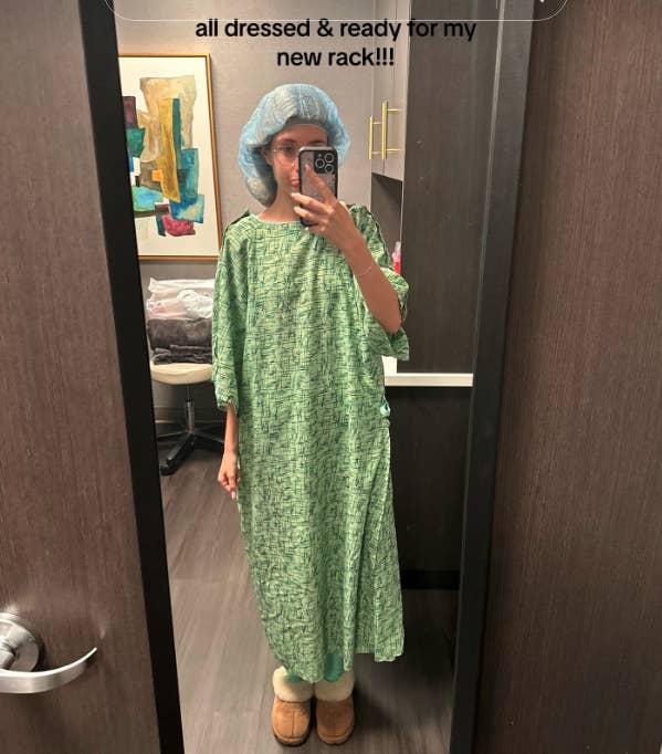 Sami takes a mirror selfie in a hospital gown, hair cap, and slippers. The caption reads, &quot;All dressed and ready for my new rack!!!&quot;