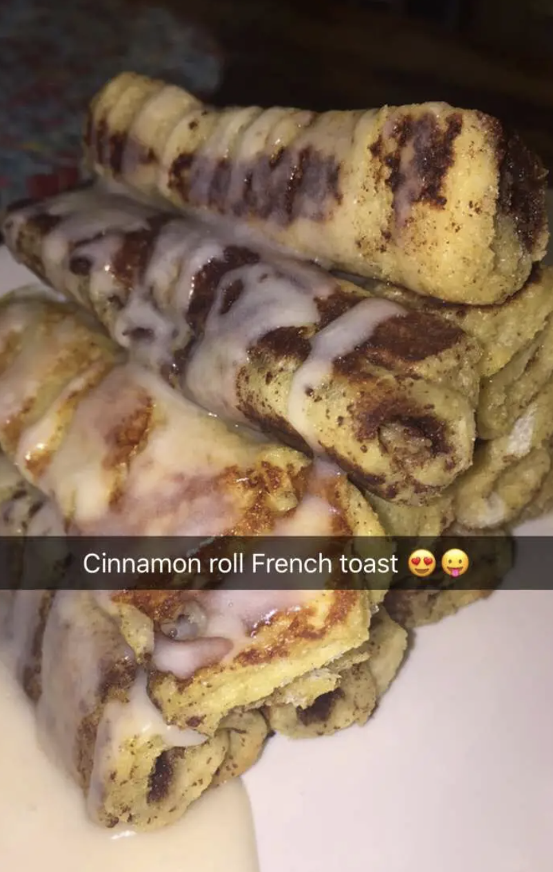 Stack of cinnamon roll French toast drizzled with icing. Text overlay reads, "Cinnamon roll French toast" with heart-eyed and tongue out emojis