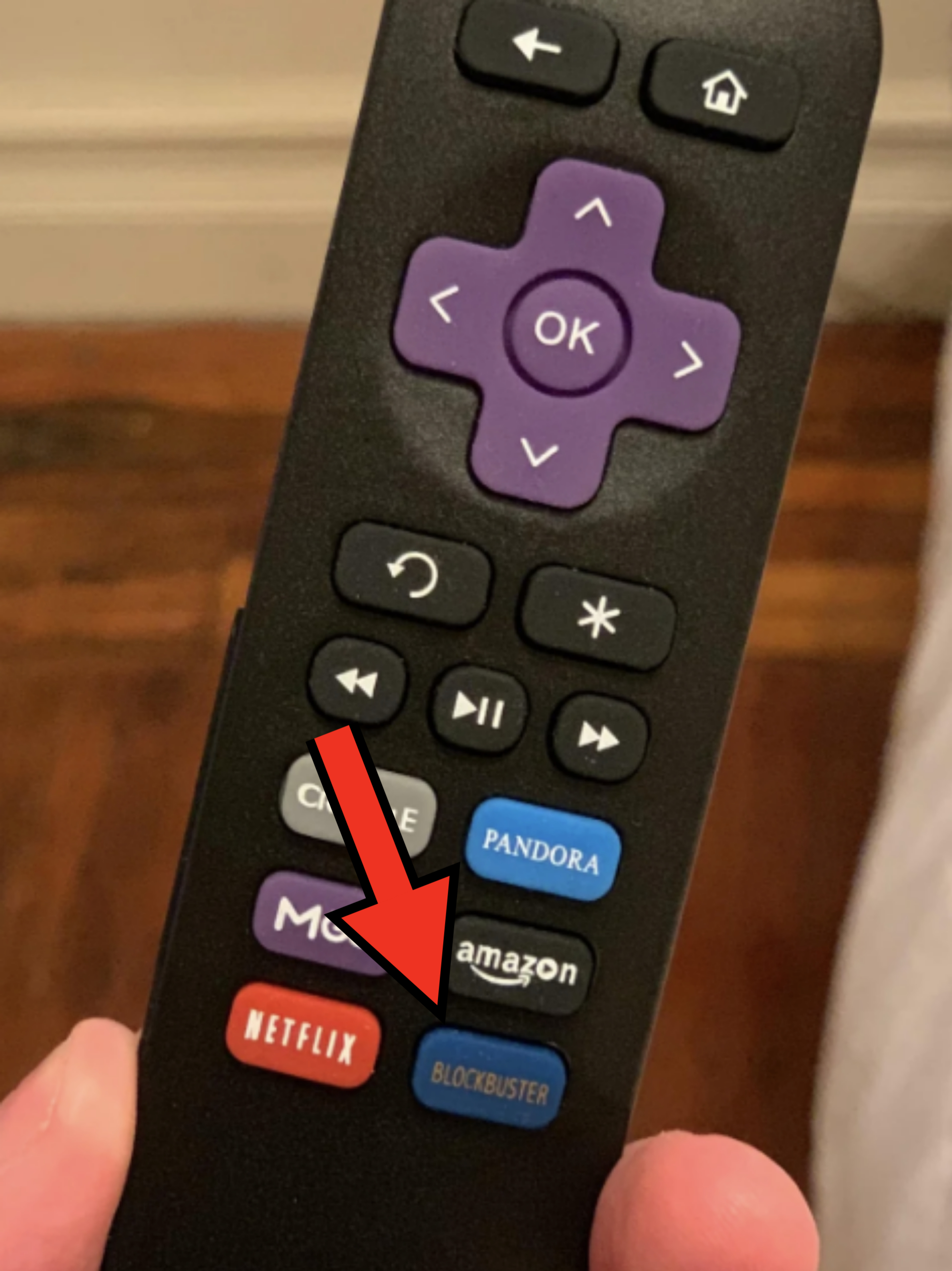 A close-up of a Roku remote with buttons for various streaming services including Crackle, Pandora, MGo, Amazon, Netflix, and Blockbuster