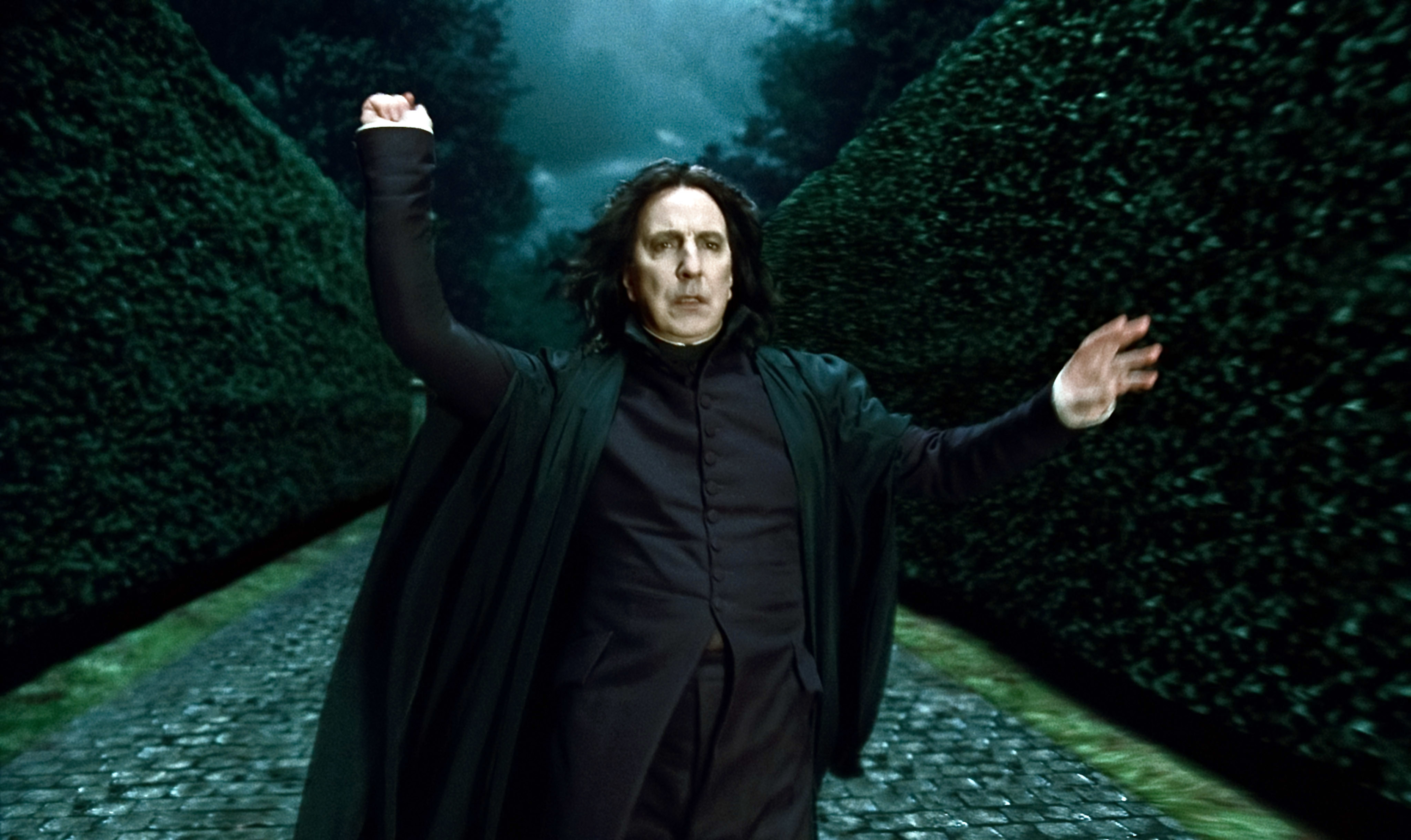 Alan Rickman as Severus Snape from Harry Potter, wearing a black cloak, casts a spell in a dark, hedge-lined path with an overcast sky