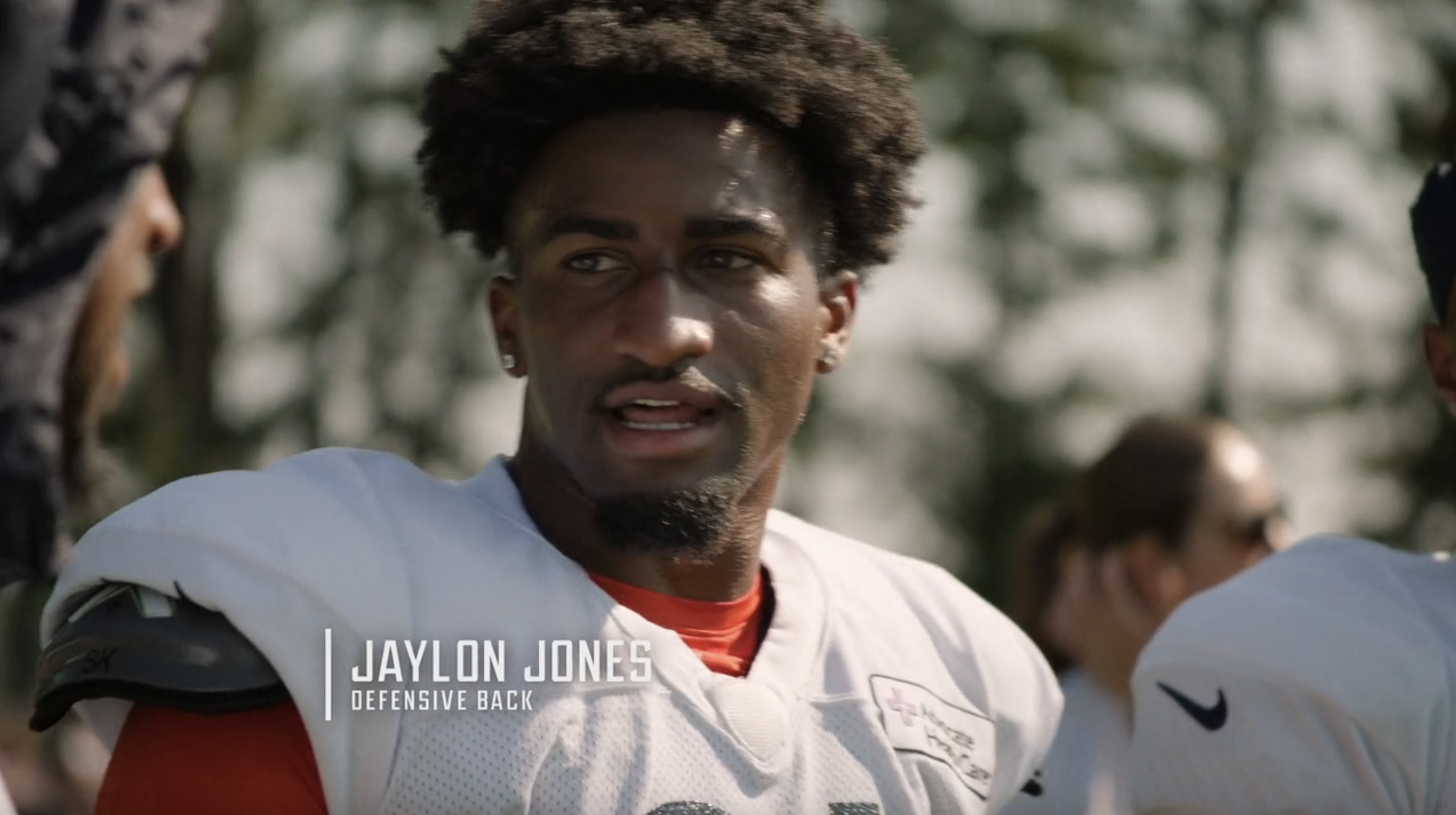 Jaylon Jones, defensive back, stands outdoors in football gear during training