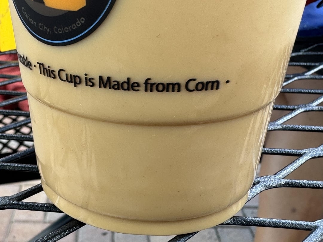 Plastic cup with "This Cup is Made from Corn" written on it but the lettering makes "corn" look like "com"