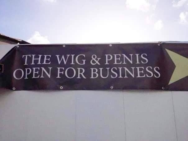 Banner reads: "The Wig & Pen is Open For Business" but the "is" is too close to "pen" so it looks like "penis"