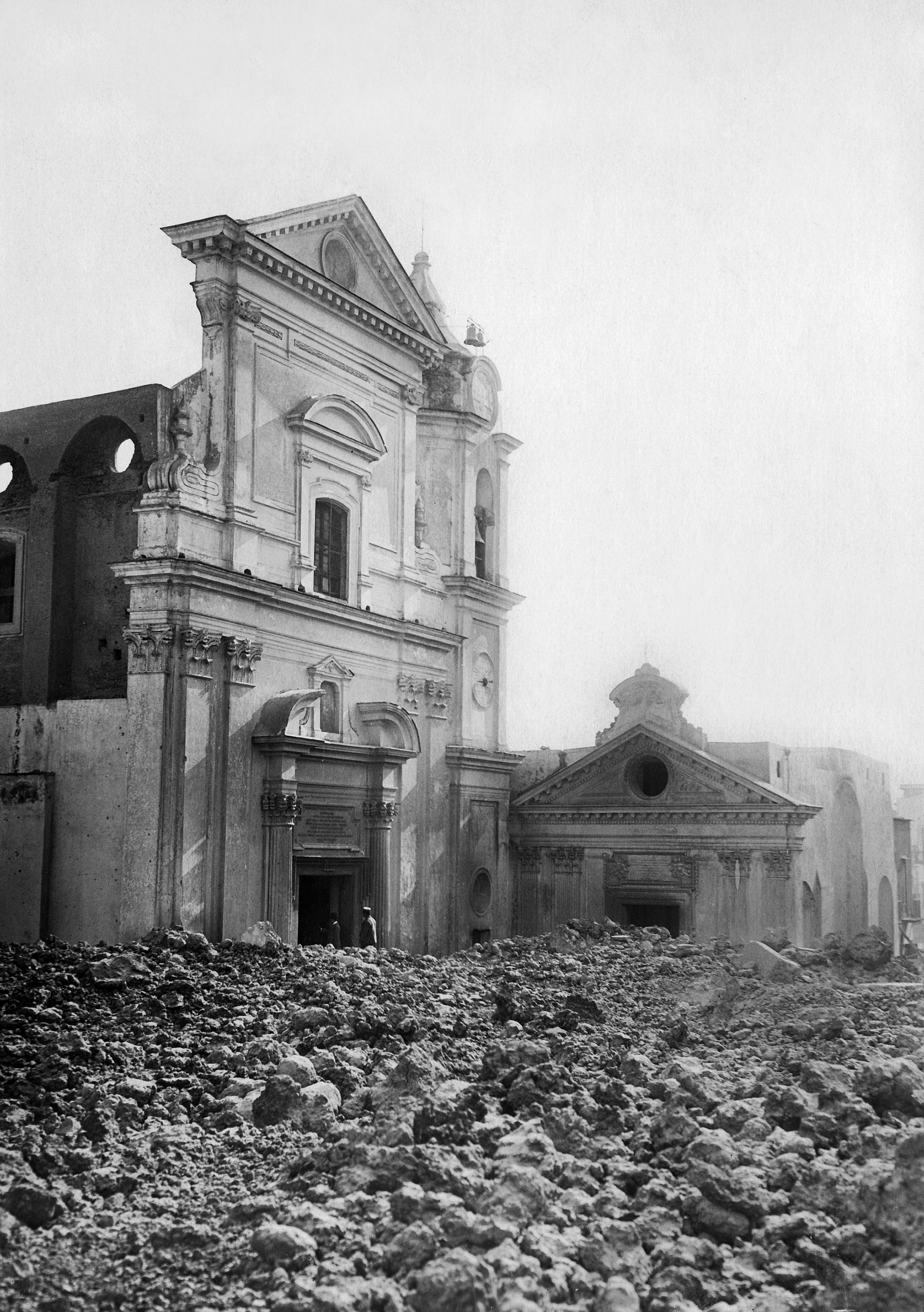 Ruins of a partially collapsed historic building with debris scattered in the foreground. No people are present