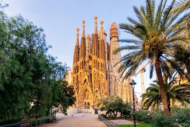 Sagrada Família, a large unfinished Roman Catholic church in Barcelona, Spain, designed by Antoni Gaudí, with intricate spires and a park in the foreground