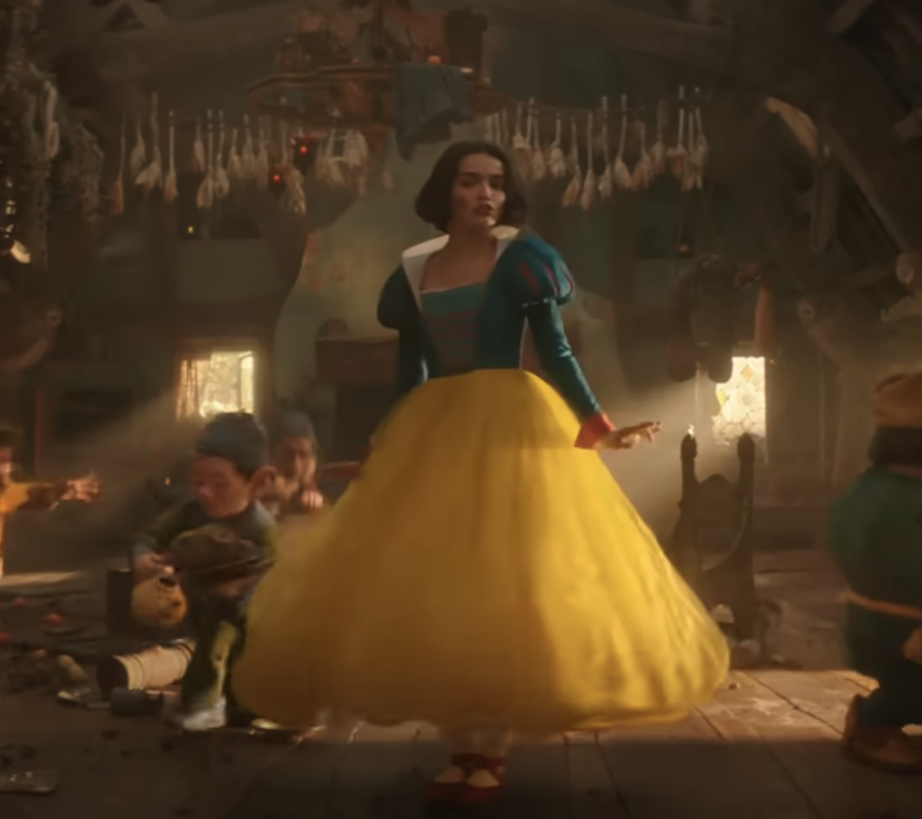 Snow White stands in the center of a rustic cabin, dressed in her iconic dress. Around her, the Seven Dwarfs are animatedly engaged in various activities