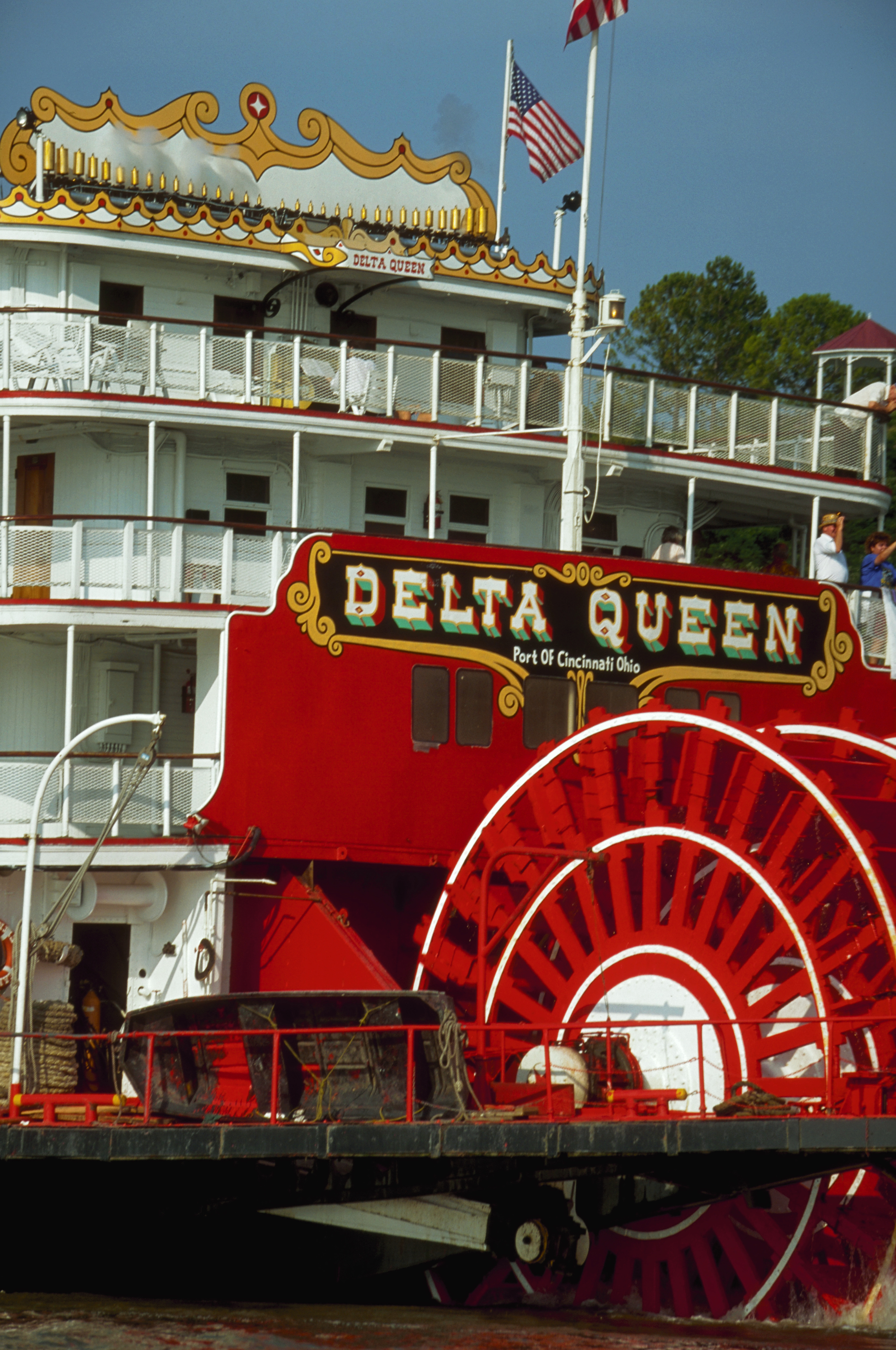 The Delta Queen steamboat shown docked, with its large paddlewheel and prominent &quot;Delta Queen&quot; signage