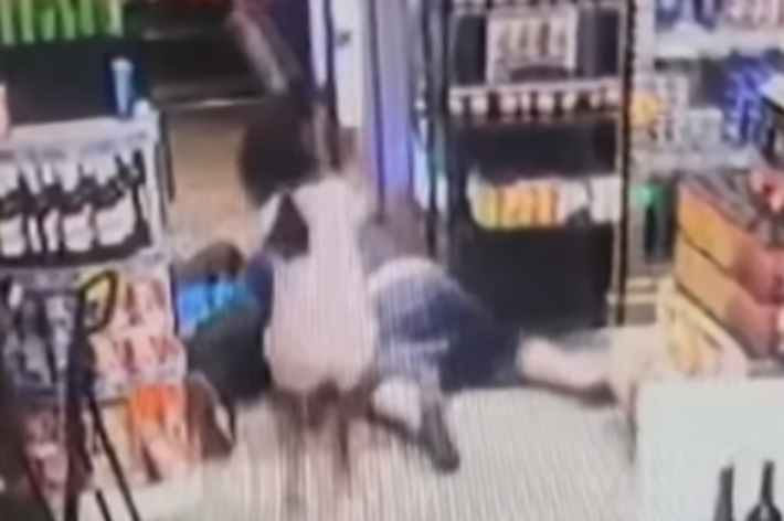 スーパー内で2人が床に倒れ、もう1人がその上に乗っている防犯カメラ映像。日付は2024年8月10日。