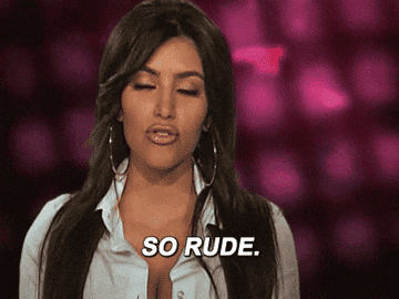 A woman with long hair and hoop earrings mouths &quot;So rude.&quot; The background is unfocused with specks of light