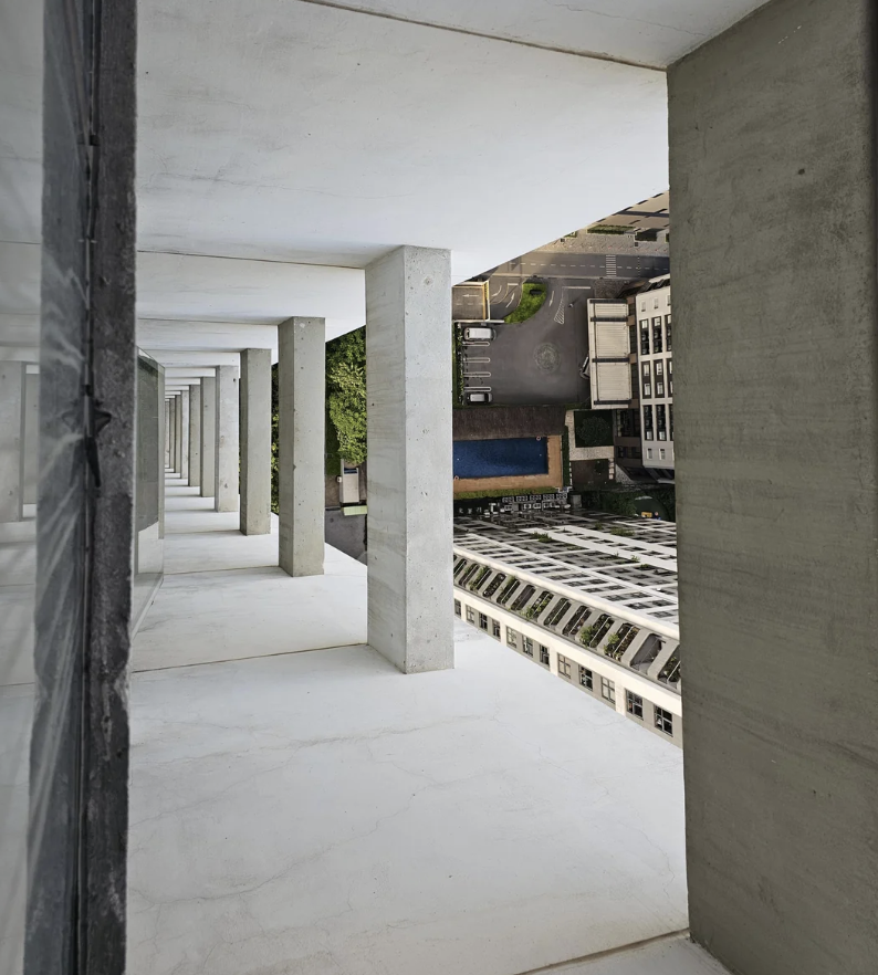 A distorted perspective photo of a building's exterior showing a row of concrete columns and a courtyard with a pool below, creating an illusion of sideways orientation