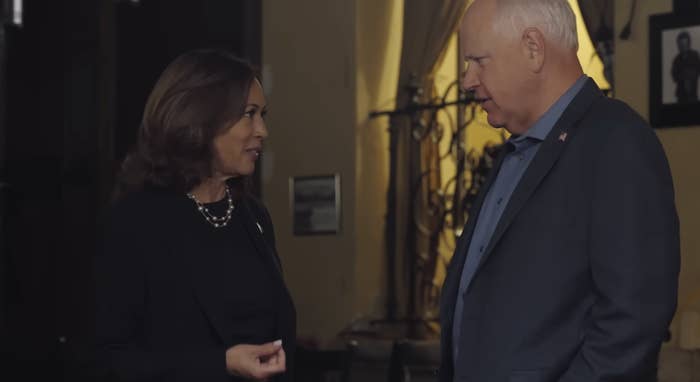 Kamala Harris speaking with Tim Walz indoors, both in formal attire