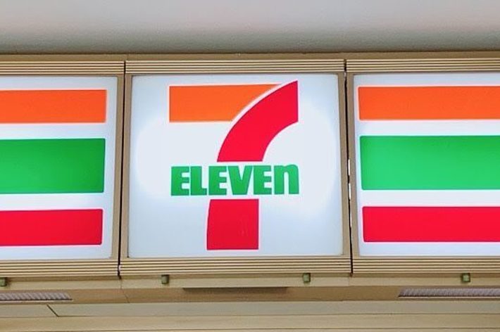 セブンイレブンの店舗入り口。自動ドアの上にセブンイレブンのロゴが表示されている。店内が部分的に見える。