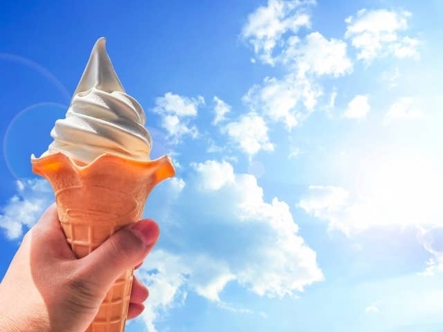 ソフトクリームを空に掲げたイメージ写真（photoACより）