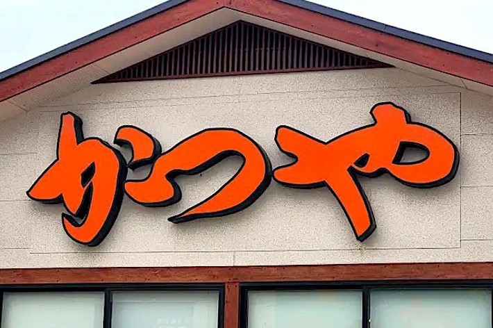 Sign with bold Japanese characters reading &ldquo;Katsuya&rdquo; on the front of a building, likely a restaurant