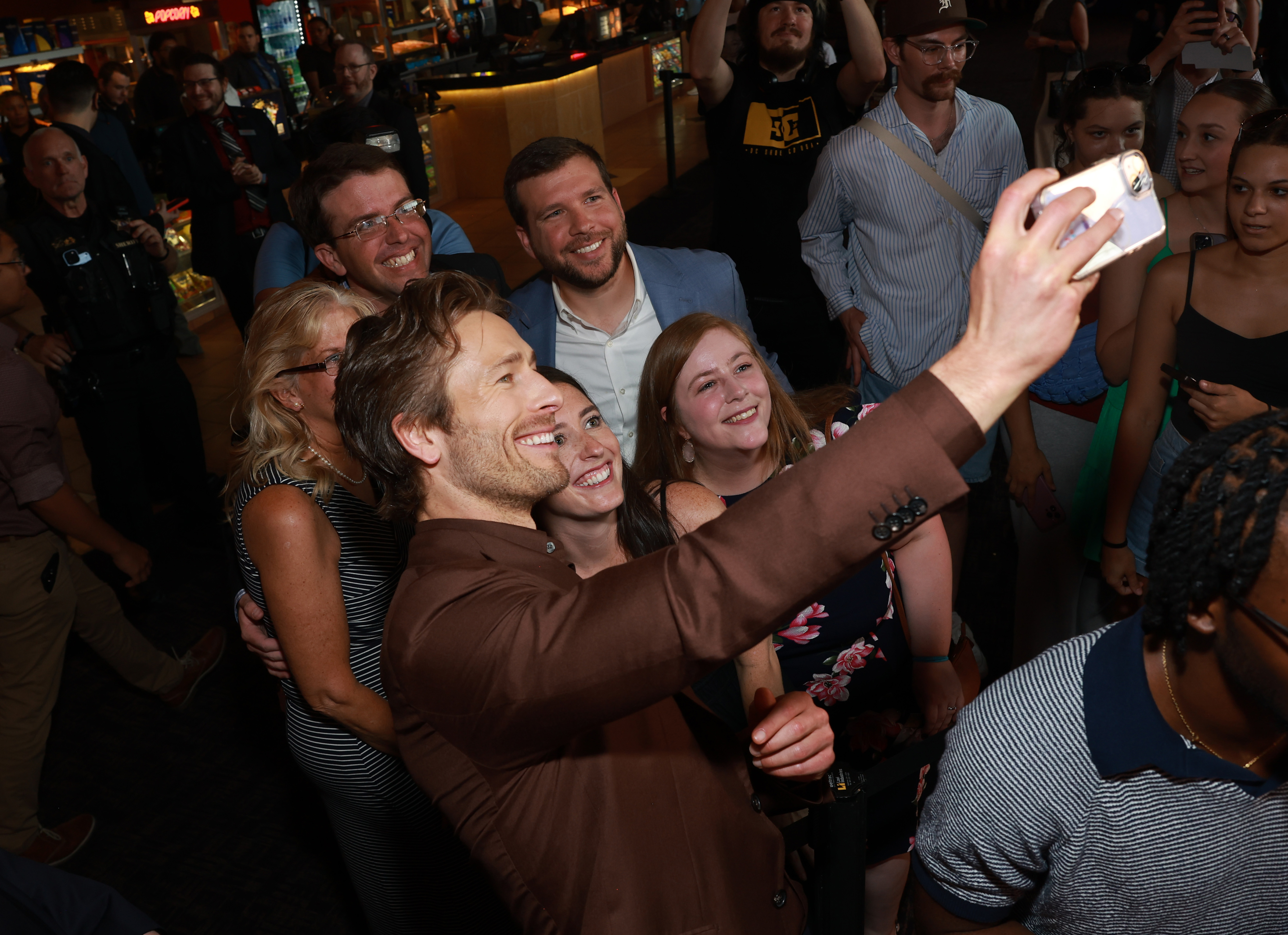 Group of fans taking a selfie with Peter Facinelli at an event, smiling and looking excited