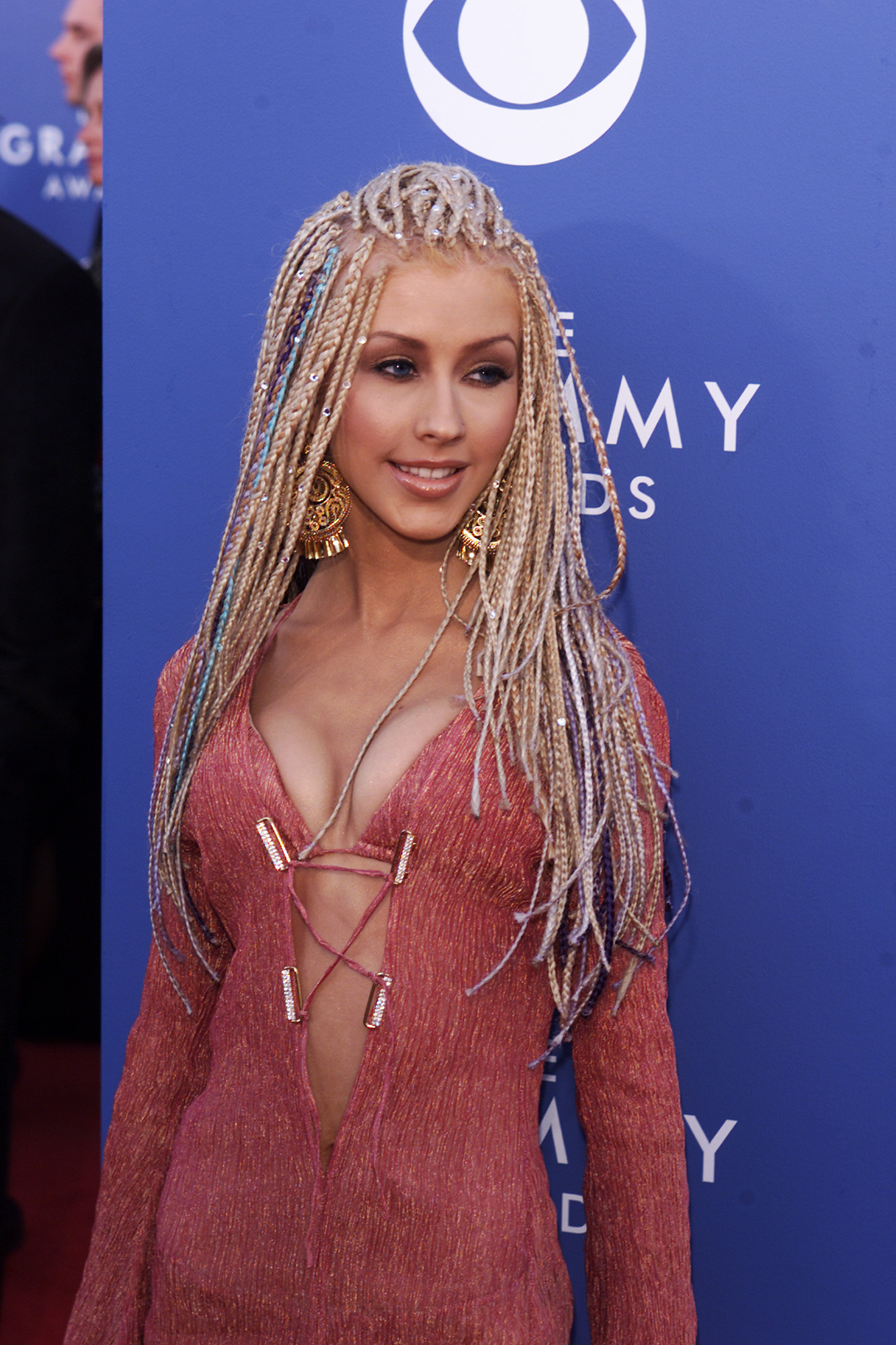 Christina Aguilera at the Grammy Awards, wearing a deep V-neck dress with a long, braided hairstyle