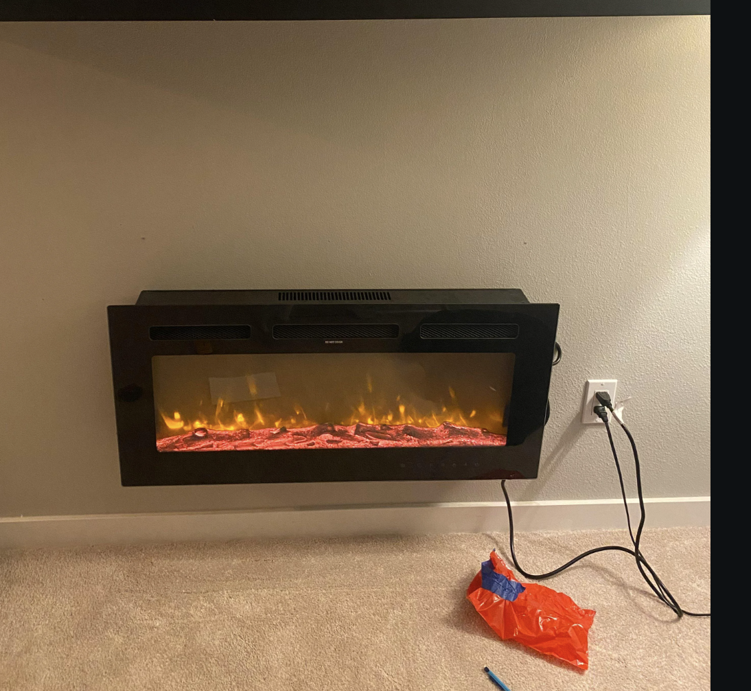 Reddit post on r/DIY showing an electric fireplace mounted on a wall, with comments and sidebar visible