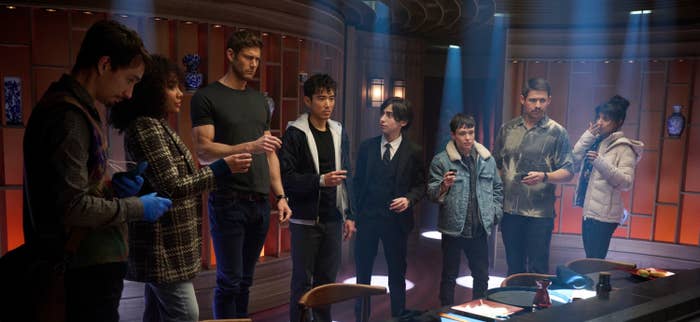 Robert Sheehan, Emmy Raver-Lampman, Tom Hopper, Justin H. Min, Aidan Gallagher, Elliot Page, David Castañeda, and Ritu Arya in a scene from Season 4 of "The Umbrella Academy"