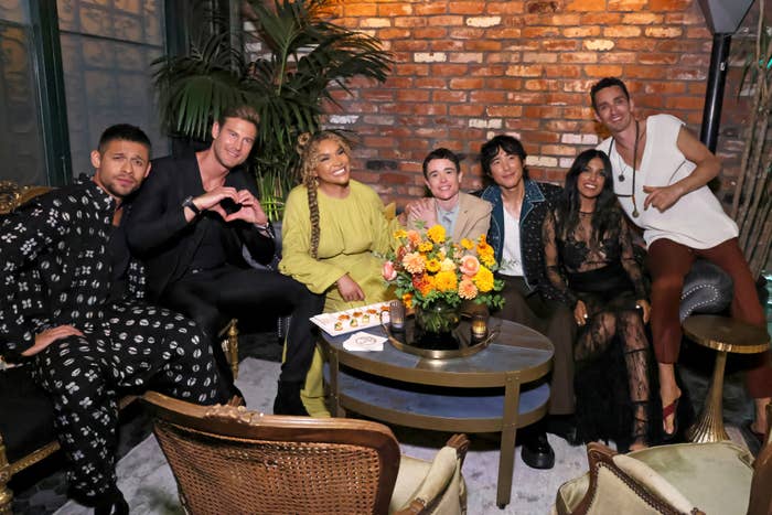 David Castañeda, Tom Hopper, Emmy Raver-Lampman, Elliot Page, Justin H. Min, Ritu Arya, and Robert Sheehan sitting together at a Netflix after party