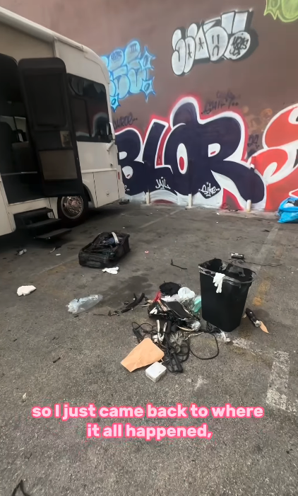 An alley with a parked van, scattered trash, and graffiti on the wall. Text at bottom reads, "so I just came back to where it all happened."