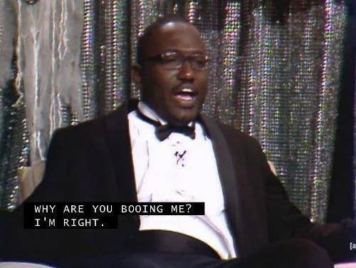 Hannibal Buress in a suit and bow tie on stage, says, &quot;WHY ARE YOU BOOING ME? I'M RIGHT.&quot;