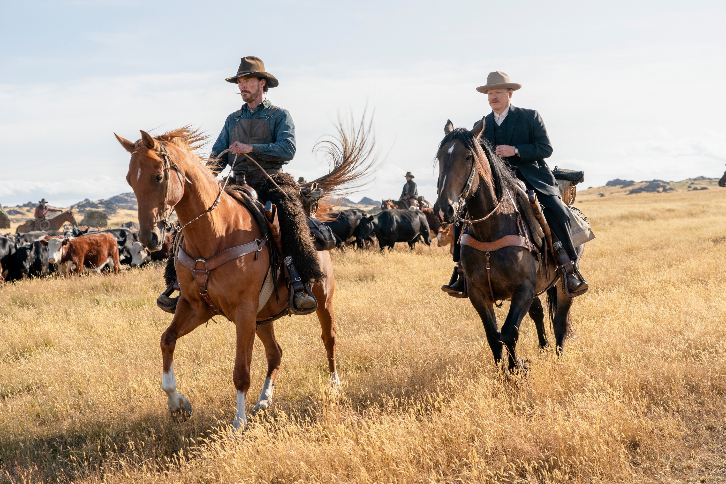 Benedict Cumberbatch and Jesse Plemons ride horses in a Western landscape from the movie "The Power of the Dog."