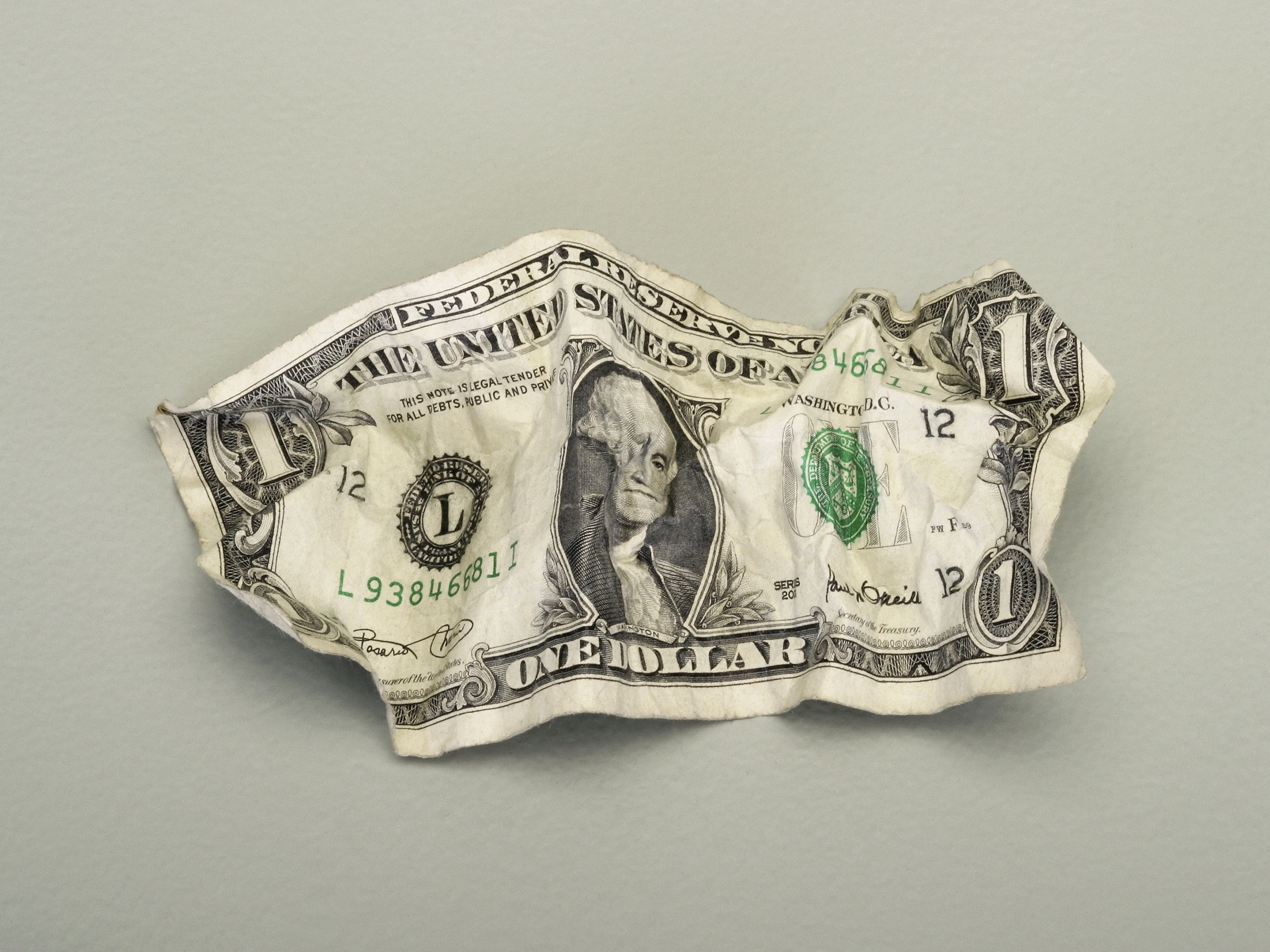 A crumpled U.S. one-dollar bill displaying George Washington's portrait