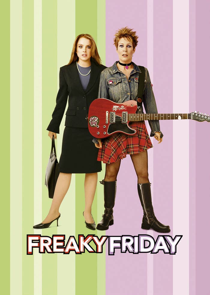 Lindsay Lohan in a black suit holding a briefcase stands beside Jamie Lee Curtis in a punk outfit with a plaid skirt, denim jacket, and holding a red guitar. Text: Freaky Friday