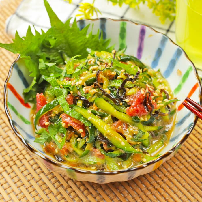 おしゃれな器に盛られた新鮮な野菜のサラダ。葉野菜とゴマがかかっており、色鮮やかでヘルシーな一品です。