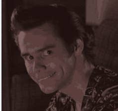 A person with a mischievous grin looking sideways at the camera, possibly from a scene in a movie. This image is categorized under Internet Finds. Names are unknown