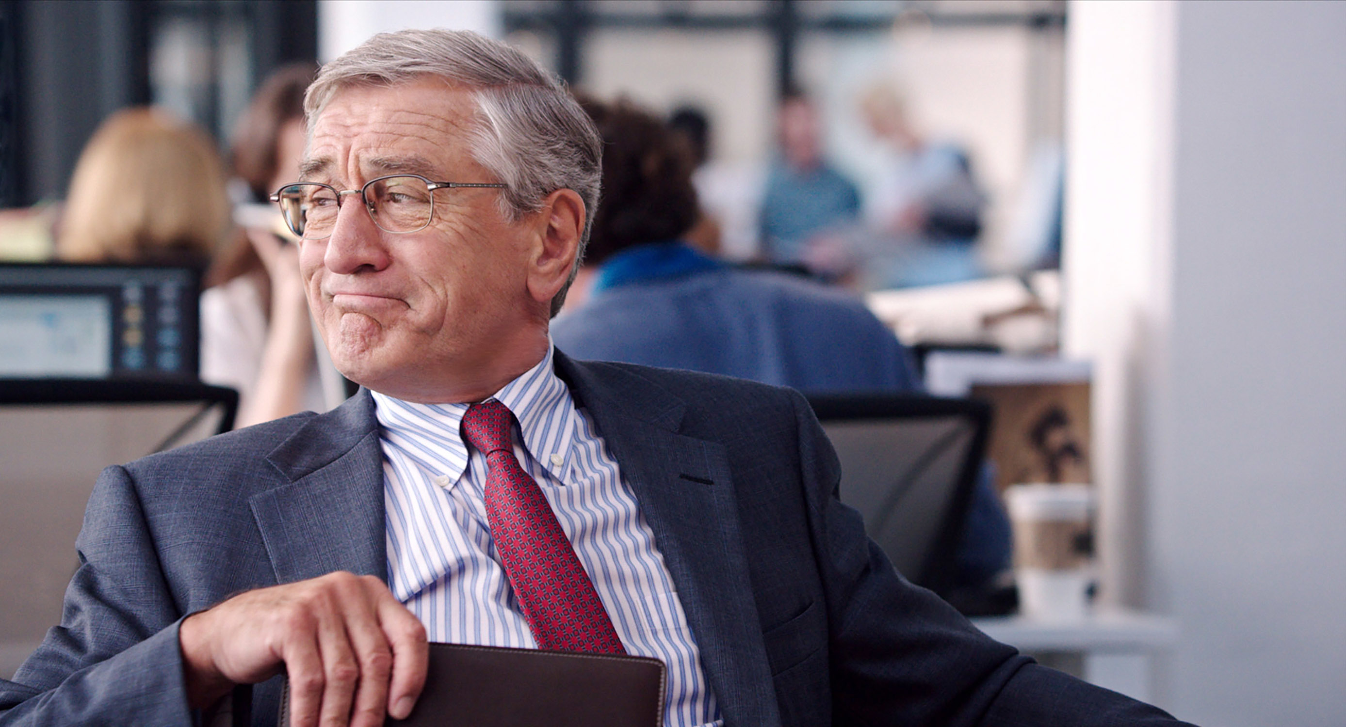 Robert De Niro in a suit and tie as he looks to the side in "The Intern"