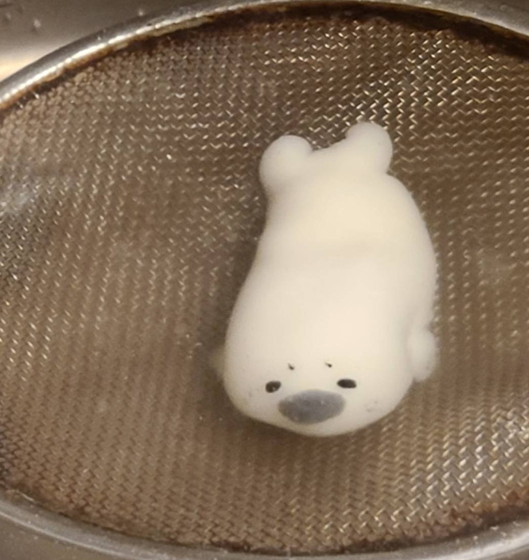 シロクマの形をした白い和菓子が金属製の網の上に置かれている。