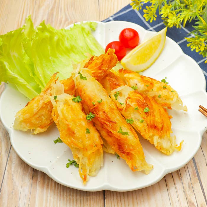 皿の上に乗ったサクサク料理、レタス、ミニトマト、レモンのスライスが添えられている。