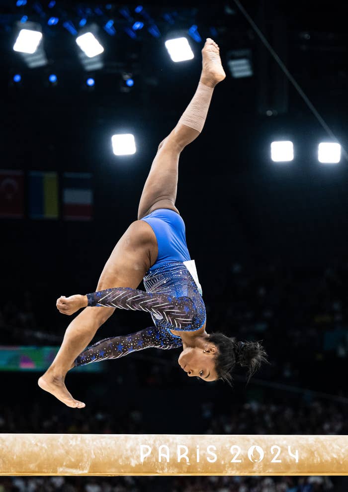 Simone Biles performs a front flip on the balance beam at the Paris 2024 gymnastics event