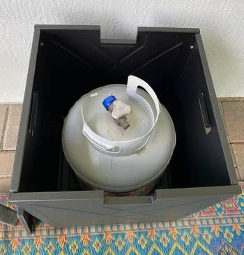 inside the hideaway tank, reviewer shows the propane tank