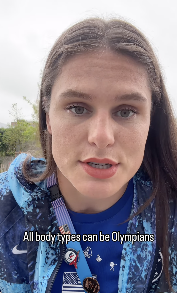 Close-up of an athlete with long hair, looking at the camera, wearing a blue sports jacket with a medal. Text reads: All body types can be Olympians