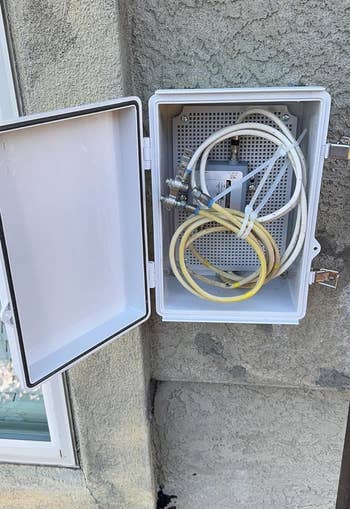 reviewer's unfastened electrical container mounted connected an exterior partition lodging respective cables and a splitter, with pebbles connected the crushed below