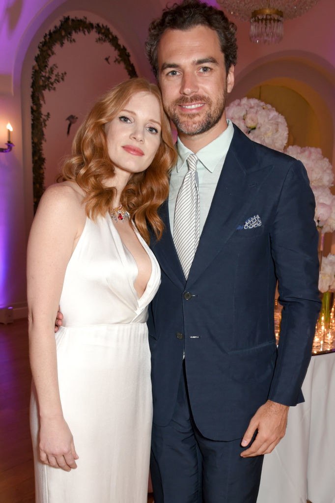Jessica Chastain in a sleeveless dress and Gian Luca Passi de Preposulo in a dark suit pose together at an elegant indoor event