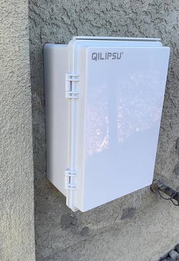 same achromatic outdoor electrical container mounted connected a partition with doorway closed