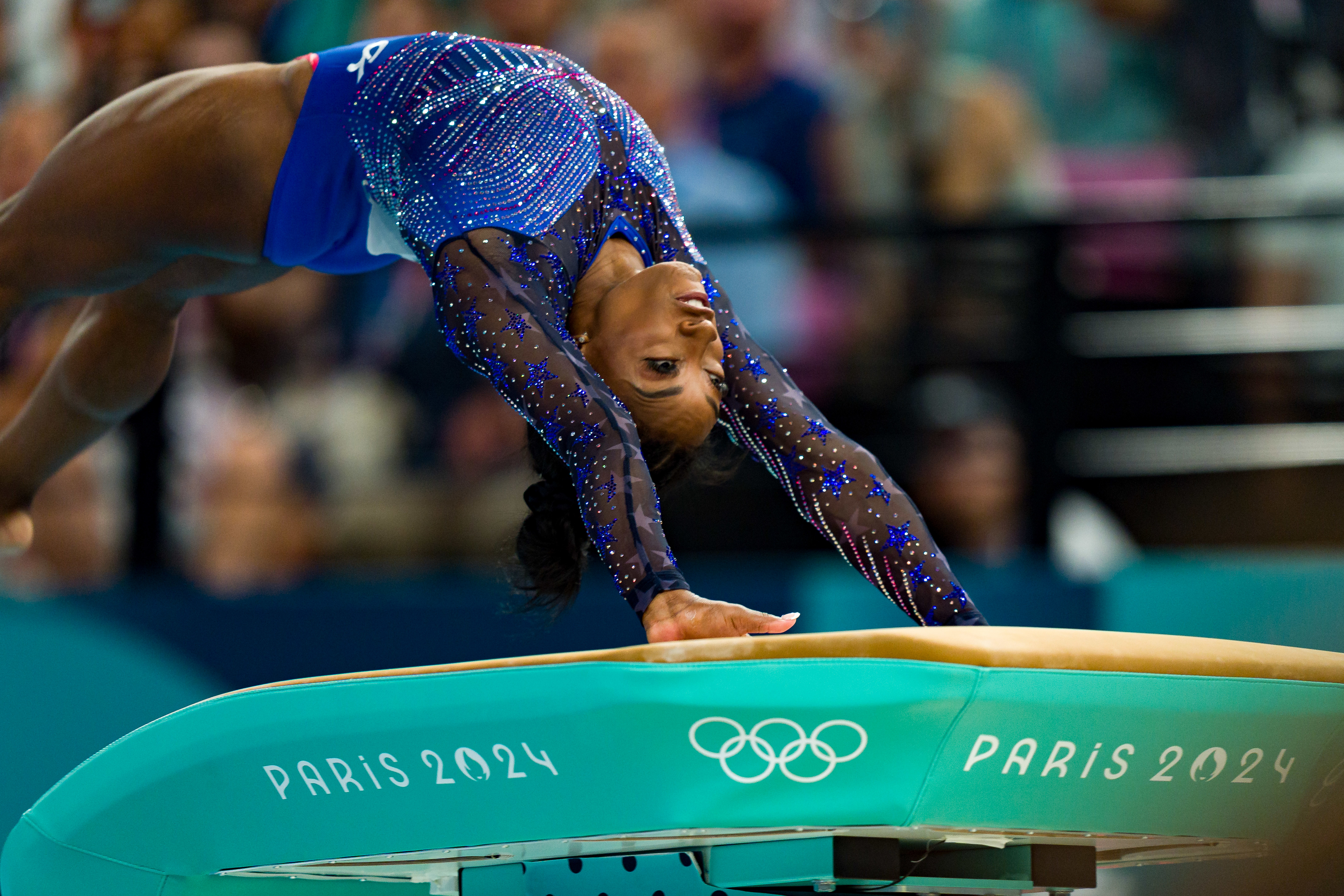 Simone Biles performs a vault routine at the Paris 2024 Olympics, displaying athleticism and focus