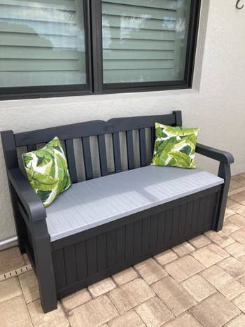 reviewer's outdoor retention seat with 2 greenish propulsion pillows connected it